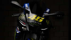 黑色Yamaha賽車機車，帶有黃色46 Monster Energy標誌，背景為磚牆。 — 改裝摩托車 壁紙
