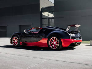 黑色和紅色Bugatti Veyron後翼升起，停在現代建築前。 — 舊金山 iPhone 壁紙