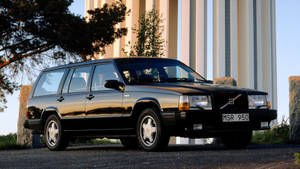 黑色富豪旅行車停在現代柱子和樹木附近。 — Mercedes Benz C300 壁紙
