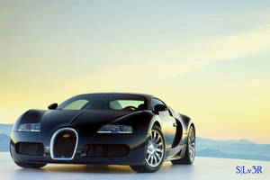 日落時分，黑色布加迪超級跑車停在平坦表面上，背景有山脈。 — Bugatti iPhone 壁紙
