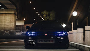 黑色日產GT-R，藍色車頭燈，夜晚停放在城市天橋下。 — 日產 壁紙
