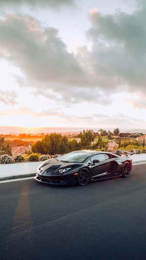 日落時分沿海公路上的黑色藍寶堅尼 Aventador SVJ — 賽車 壁紙