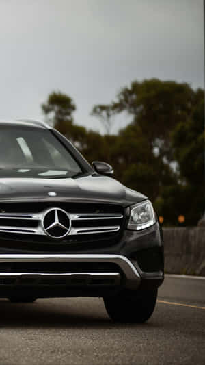 黑色賓士SUV停在路上，後面有樹木。 — Mercedes Benz C300 壁紙