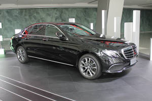 黑色賓士轎車在現代豪華汽車展示間中展示。 — Mercedes Benz C300 壁紙