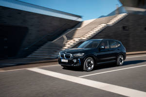 黑色BMW SUV在街道上快速行駛，背景模糊 — Mercedes Benz C300 壁紙