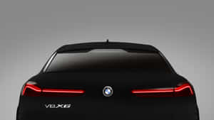 黑色BMW V8X6汽車後視圖，紅色尾燈亮起。 — 簡約暗黑美學 壁紙