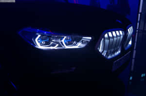 BMW汽車在藍光下照亮頭燈和格柵的特寫。 — MacBook Air 13 壁紙