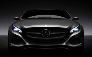 黑色賓士汽車正面視圖，車頭燈在昏暗的攝影棚中亮起。 — Mercedes Benz C300 壁紙