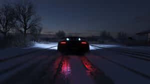 黑色跑車在雪地道路上夜間行駛，紅色尾燈發光。 — 電玩遊戲 GIF 壁紙