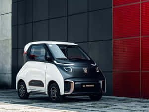 緊湊型電動車停在紅色和灰色牆前。 — 好看汽車 壁紙