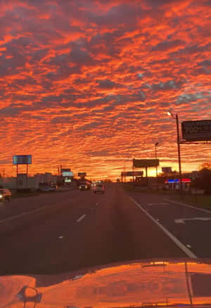 黃昏時分的高速公路，上方是火紅橙色的天空。 — 假期 壁紙