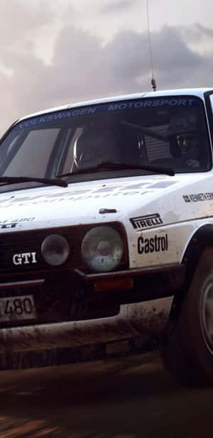 沾滿泥濘的白色拉力賽車，帶有Castrol和Pirelli標誌，在泥濘賽道上飛馳。 — Pixel 4 壁紙
