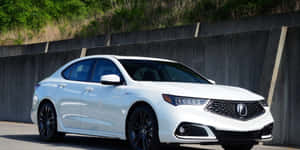 白色豪華轎車配黑色輪圈停放在混凝土牆旁邊。 — Acura 壁紙