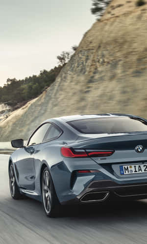 藍色BMW 8系列轎跑車在日落時分的山路上奔馳 — Galaxy Tab S9 Ultra 壁紙