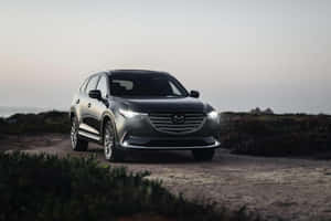黑色Mazda CX-9 SUV停泊在海岸泥路，暮色時分。 — 馬自達 壁紙