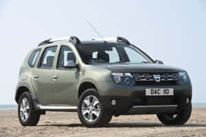 橄欖綠色的Dacia Duster SUV停放在沙灘上，天空晴朗。 — Surface Laptop 壁紙