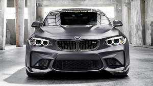 混凝土倉庫內帶金色飾邊的消光灰色BMW M2跑車。 — Mercedes Benz C300 壁紙