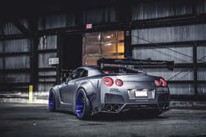 訂製消光灰色日產GT-R，配備藍色輪圈，停放在黑暗的倉庫中。 — 日產GTR 壁紙