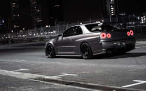 消光灰色日產Skyline GT-R，紅色尾燈，夜晚停在城市街道上。 — 街頭 壁紙