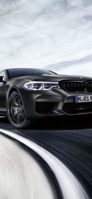 消光黑色BMW M5在道路上疾駛，帶有動態模糊。 — Galaxy A07 壁紙