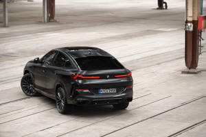 消光黑色BMW X6 M SUV停放在混凝土上，紅色尾燈發光。 — Mercedes Benz C300 壁紙