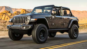 日落時分黑色Jeep Rubicon在沙漠道路上行駛 — 吉普 壁紙