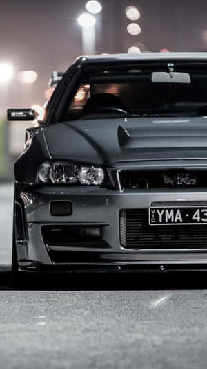 黑色日產Skyline R34在夜晚停泊在城市的街燈下。 — 日產 Skyline GTR R34 壁紙