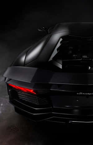 消光黑色藍寶堅尼 Aventador 配紅色尾燈，在黑暗攝影棚中 — 悟空黑 iPhone 壁紙