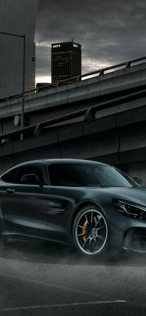 黑色跑車在黃昏時分的城市高架橋上甩尾，伴隨著煙霧 — 高清汽車 壁紙