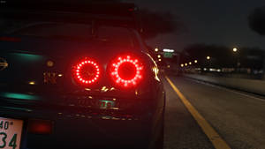 夜間在黑暗高速公路上飛馳的日產GT-R的紅色尾燈。