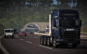 藍色 Scania 卡車在山區高速公路上駛向隧道，背景為森林。 — 卡車 壁紙