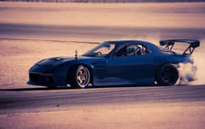藍色飄移車在日落時分的塵土賽道上揚起煙霧 — 馬自達 壁紙