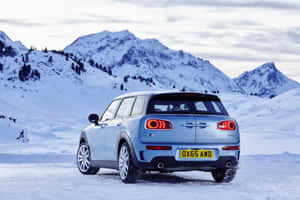 淺藍色Mini Cooper Clubman停放在雪地山景中。 — Surface Pro 壁紙