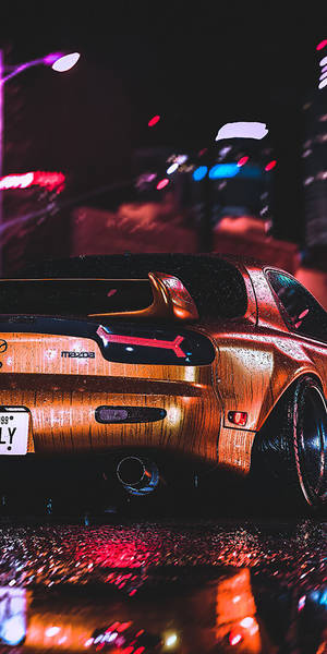 一輛時尚跑車在夜間停泊在濕漉漉的城市街道上，周圍是色彩繽紛的霓虹燈。 — 城市燈光 壁紙
