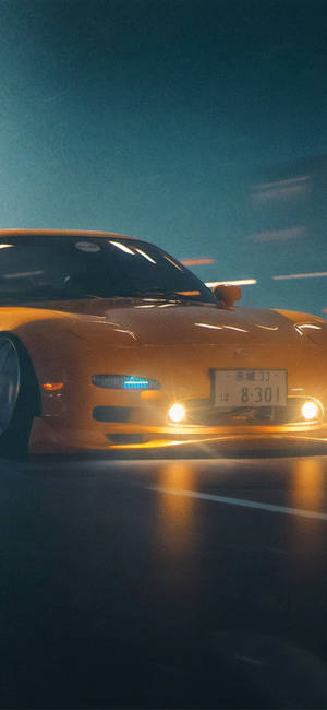 橙色跑車在夜間於潮濕街道上疾馳，車頭燈發出光芒。 — iPhone 16 Pro Max 壁紙