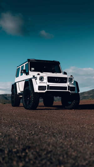 白色 Mercedes G-Wagen 停在碎石路上，日落時分 — 卡車 壁紙