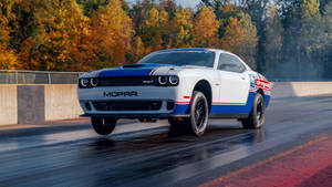 白色、藍色和紅色的Mopar Dodge Challenger SRT在秋日落日時分在潮濕的賽道上漂移。 — 道奇挑戰者 壁紙