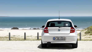 白色BMW 1系列停泊在海邊碎石上 — Mercedes Benz C300 壁紙