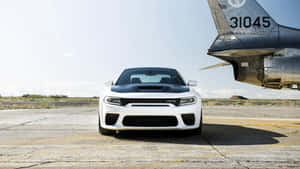 白色Dodge Challenger SRT Hellcat停放在機場的軍用噴射機旁邊。 — 旋風戰車隊 壁紙