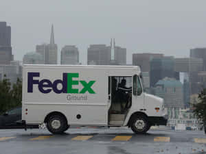 FedEx貨車停放在雨天城市，背景有天際線 — 聯邦快遞 壁紙