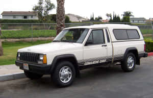 白色Jeep Cherokee Comanche Chief停放在郊區停車場，有棕櫚樹。 — Steam Deck 壁紙