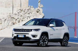 白色Jeep Compass SUV停放在歷史紀念碑和紅色大橋附近。 — 假期 壁紙