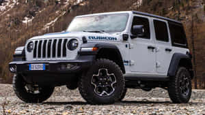 白色Jeep Rubicon停放在靠近雪山的多岩石地形上。 — 吉普 壁紙