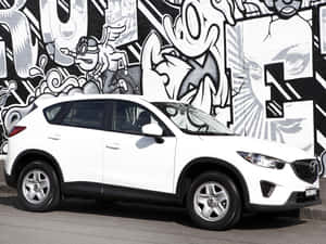 白色Mazda CX-5 SUV停在一幅充滿活力的塗鴉牆旁。 — 馬自達 壁紙