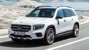 白色Mercedes-Benz GLB SUV在海岸公路上行駛，帶有動態模糊效果。 — 好看汽車 壁紙