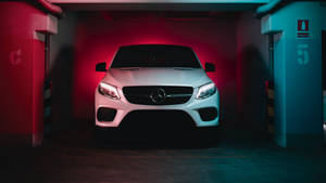 白色Mercedes SUV停放在帶有紅色和藍色照明的霓虹燈地下車庫中。 — Mercedes Benz C300 壁紙