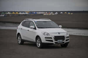 白色SUV停泊在沙灘上，背景有沙灘帳篷。 — 低飽和 壁紙