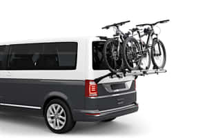 白色和灰色的廂型車，車頂架上載有兩輛自行車。 — 汽車 壁紙