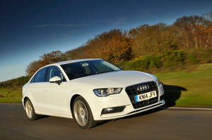白色奧迪轎車在風景如畫的鄉村道路上行駛，周圍是秋葉。 — 奧迪 GIF 壁紙