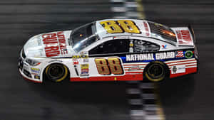 一輛編號88的NASCAR賽車在夜間賽道上奔馳。 — 汽車 壁紙